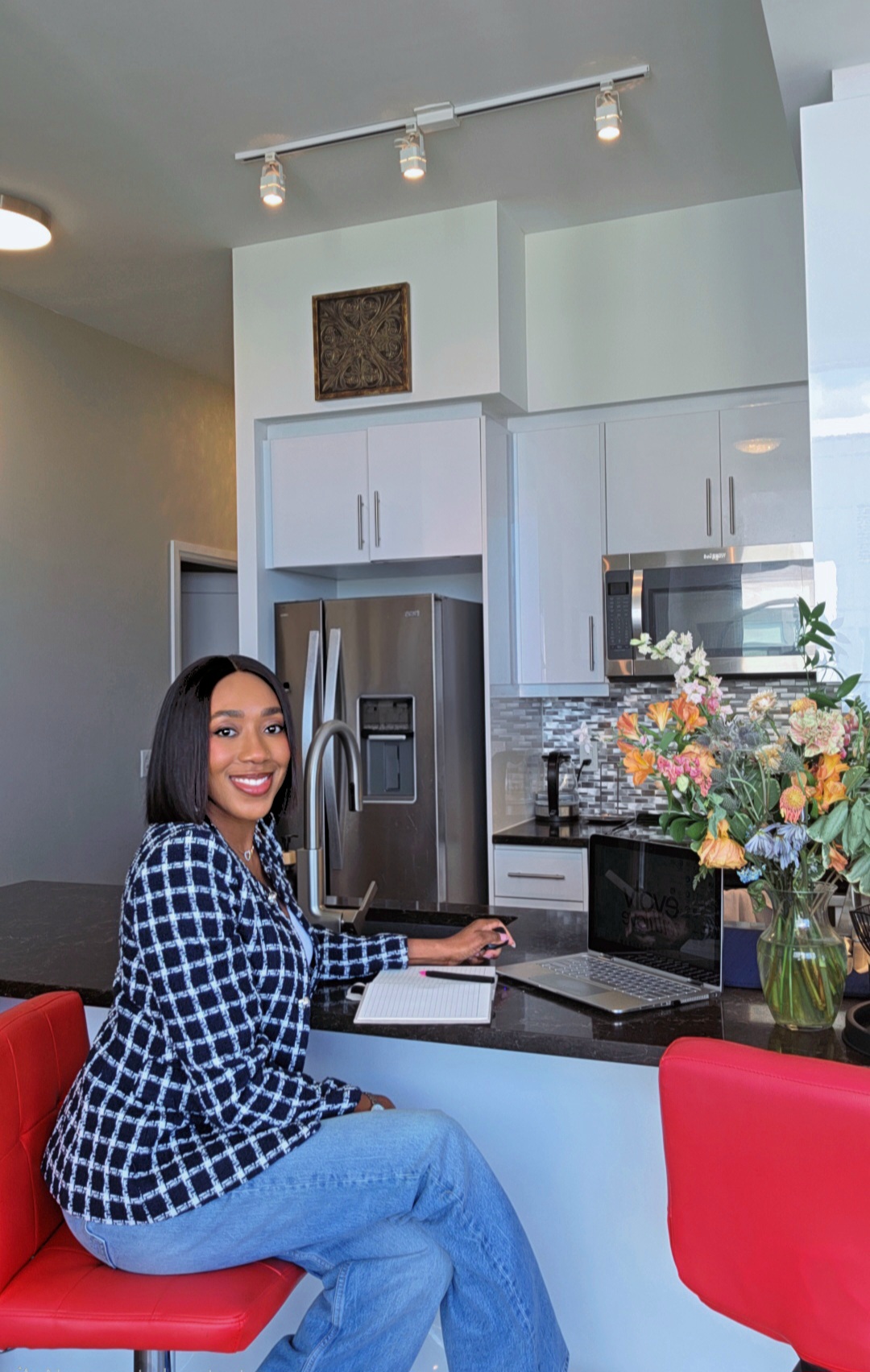 Love working beside her laptop and notebook at the kitchen counter