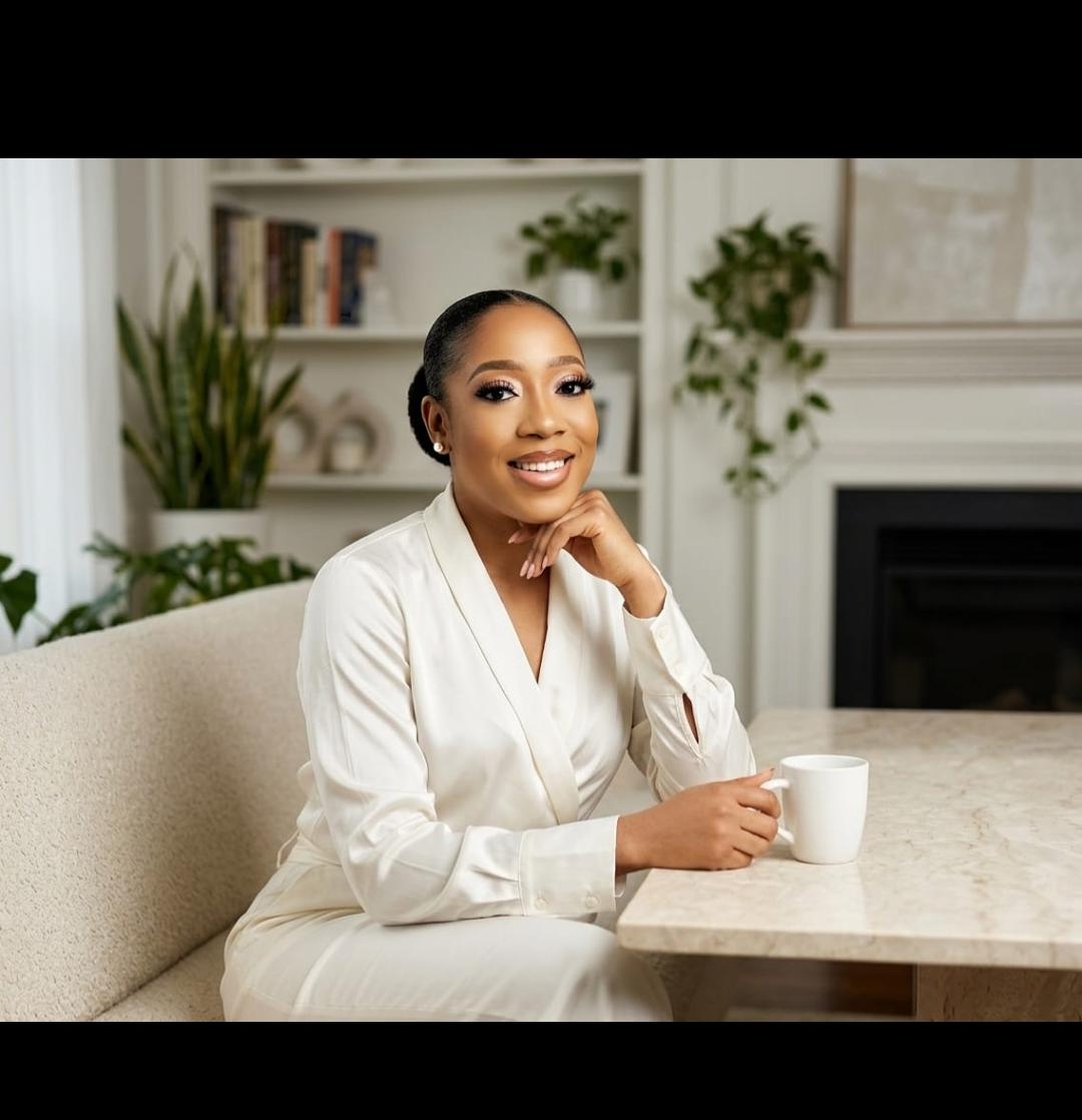 Love seated at a table in a white suit